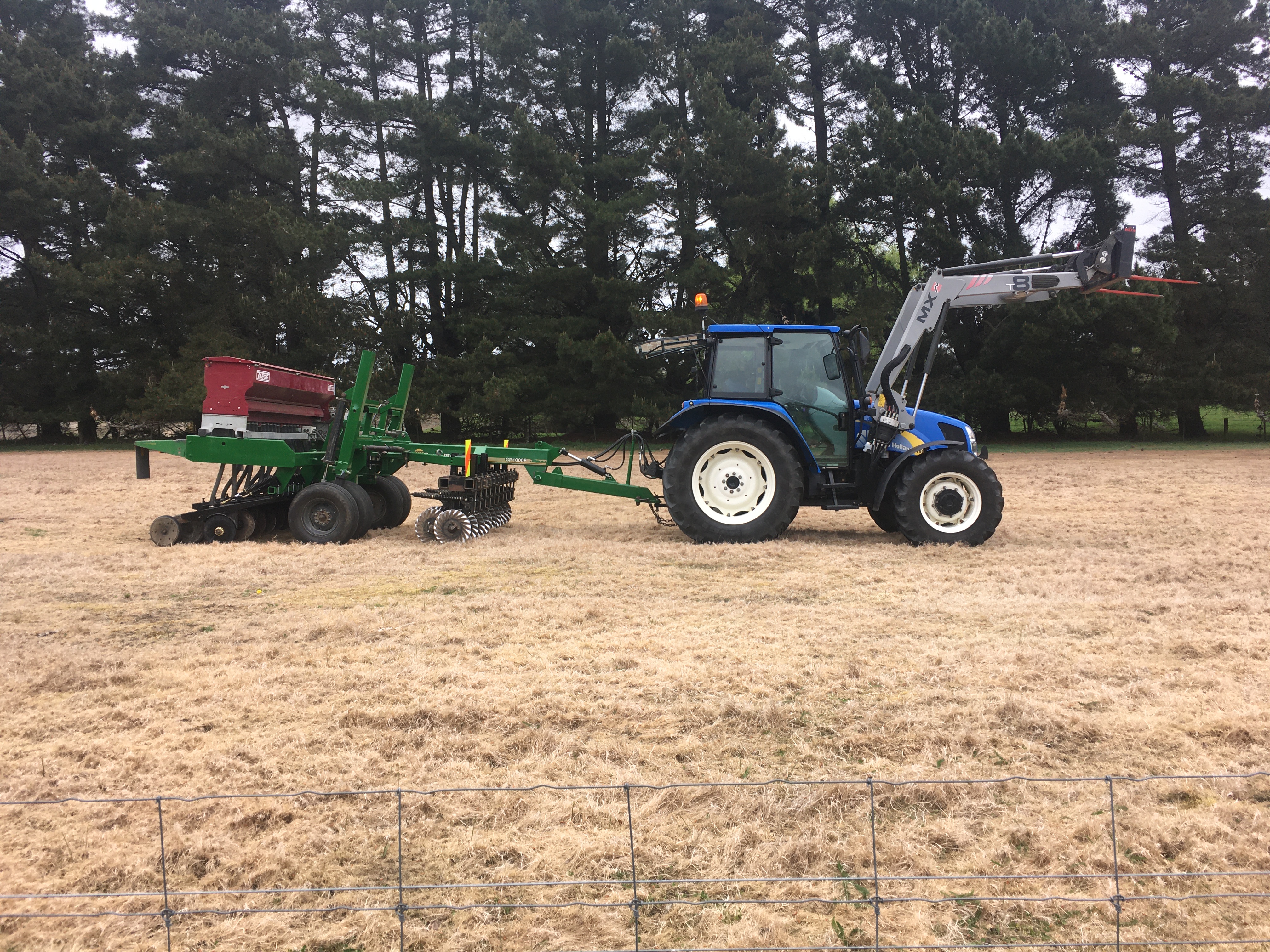 New Holland tractor and Taege drill seeder sitting in a paddock